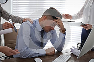 Businessman stressing out at workplace in office photo