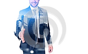 Businessman stretching out hand to shake, skyscrapers and copy space