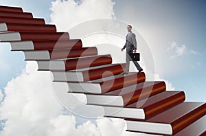 Businessman student climbing the ladder of education books