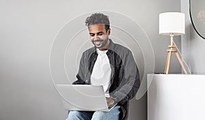 Businessman or student using laptop computer at home. Young man working.
