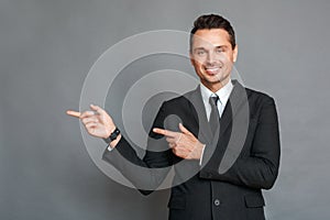 Businessman studio standing isolated on grey pointing on space aside smiling happy