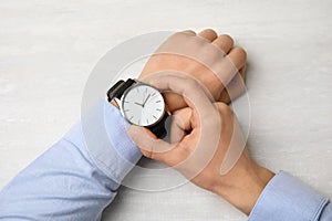 Businessman with stylish wrist watch at table