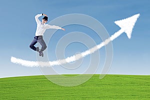 Businessman success jump over arrow cloud