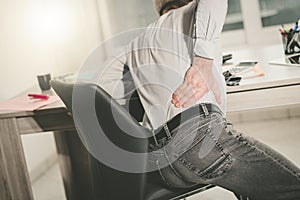 Businessman suffering from back pain, light effect