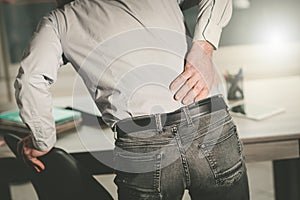 Businessman suffering from back pain, light effect