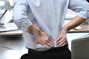 Businessman suffering from back pain at workplace