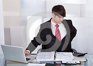 Businessman suffering from backache at desk