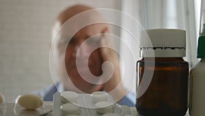 Businessman Suffering a Big Migraine Look in Medicine Cabinet for Pills