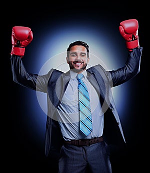 Businessman in a suit and boxing gloves, celebrating a win.