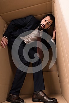 Businessman with claustrophobia inside a box