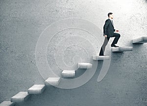 Businessman in suit climbing on concrete ladder