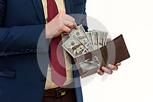 Businessman in suit gets us money from the wallet, isolated. Male hands holding a black leather wallet with US Dollars cash inside