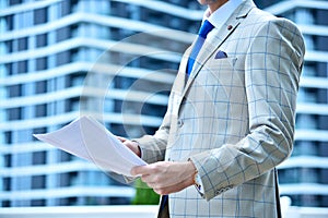 Businessman in suit holding business report in hands