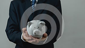 Businessman in suit is holding piggy bank.financial investments and savings money, management and accounting concept