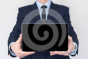 Businessman in a suit holding a tablet computer with isolated screen. Presentation mock-up