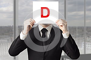 Businessman in suit holding up sign with letter d