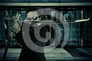 Businessman with suit and Japanese sword, office building