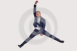 A businessman in a suit jumps for joy.