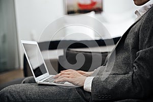 Businessman in suit with a laptop on his lap