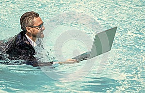 Businessman in suit with laptop in swimming pool. business man on summer vacation. businessman in wet suit in swim pool