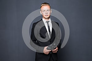 Businessman in suit looking through binoculars in hands with gray background