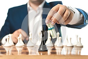 Businessman in suit make move with dollars in chess game