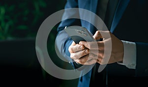 Businessman in suit with mobile phone in hands. Man typing message, using social net. Checking news. Making business