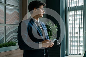 Businessman in suit with mobile phone in hands. Man typing message, using social net. Checking news. Making business