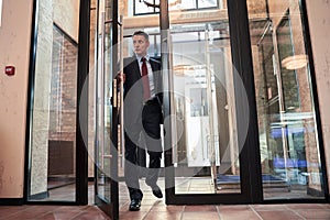 Businessman in suit opening office door