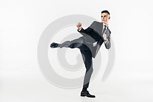 businessman in suit performing karate kick