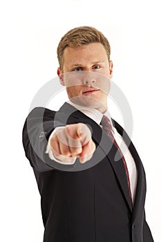 Businessman in suit pointing finger at camera