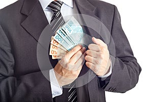 Businessman in a suit putting money in his pocket