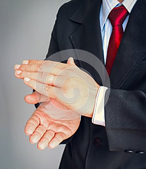 Businessman in suit with red tie showing gesture applaud