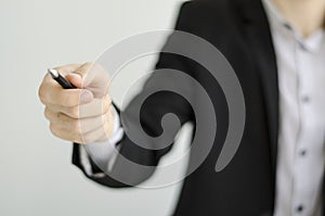 Businessman in suit showing something with pen.