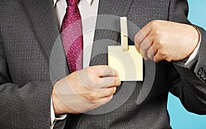 Businessman in suit shows his badge, where sticker and clothespin is attached instead of nametag