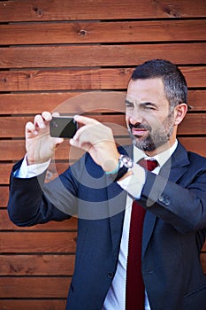 Businessman in a suit taking photograph