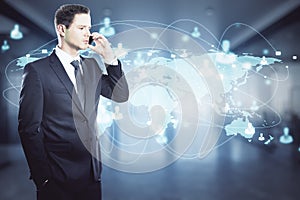 Businessman in a suit talking on the phone with a world map with rays in the background. International and worldwide trade concept