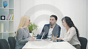 Businessman in suit talking to business people colleagues or partners sitting at conference table in 4k video.