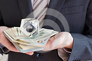 Businessman in suit, tie holds in hands drop of black oil of Brent brand in crystal cube.Pack of hundred dollars bills.Crisis in