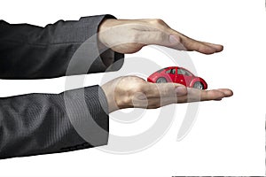 Businessman in suit with two hands in position to protect a car