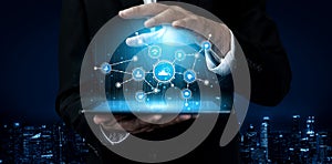 Businessman in Suit Using Tablet to Display Digital Data Visualization with Graphs and Network Icons Against a Dark