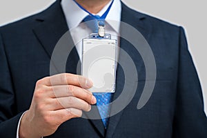 Businessman in suit wearing a blank ID tag or name card on a lanyard at an exhibition or conference