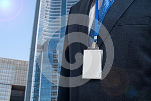 Businessman in suit wearing a blank ID tag or name card on a lanyard at an exhibition or conference