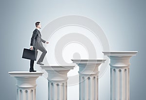 Businessman with suitcase, columns stairs, gray