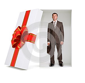 Businessman with suitcase in gift box on white