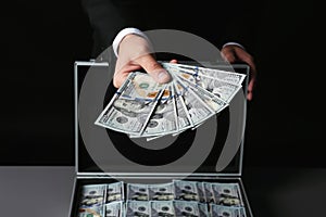 Businessman with suitcase offering money