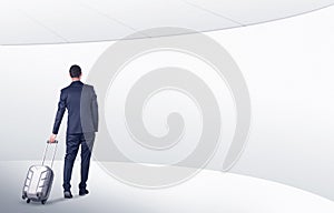 Businessman with suitcase walking in waiting room