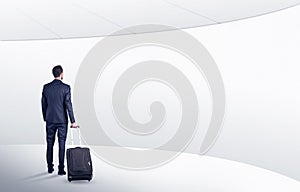 Businessman with suitcase walking in waiting room