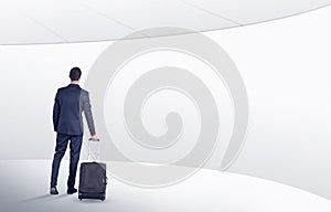 Businessman with suitcase walking in waiting room