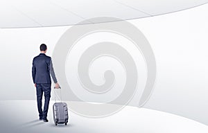 Businessman with suitcase walking in waiting room